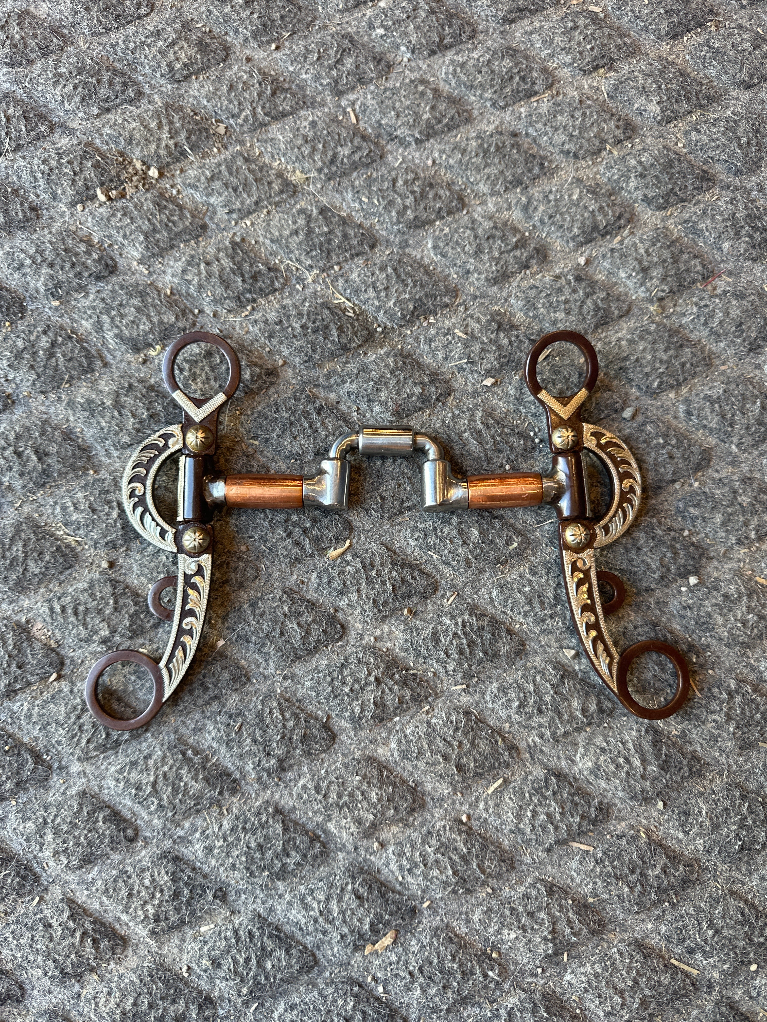 Hinged correction bit with copper barrels and antique cheeks