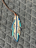 Leopard on earth tones painted feather tie on saddle charm
