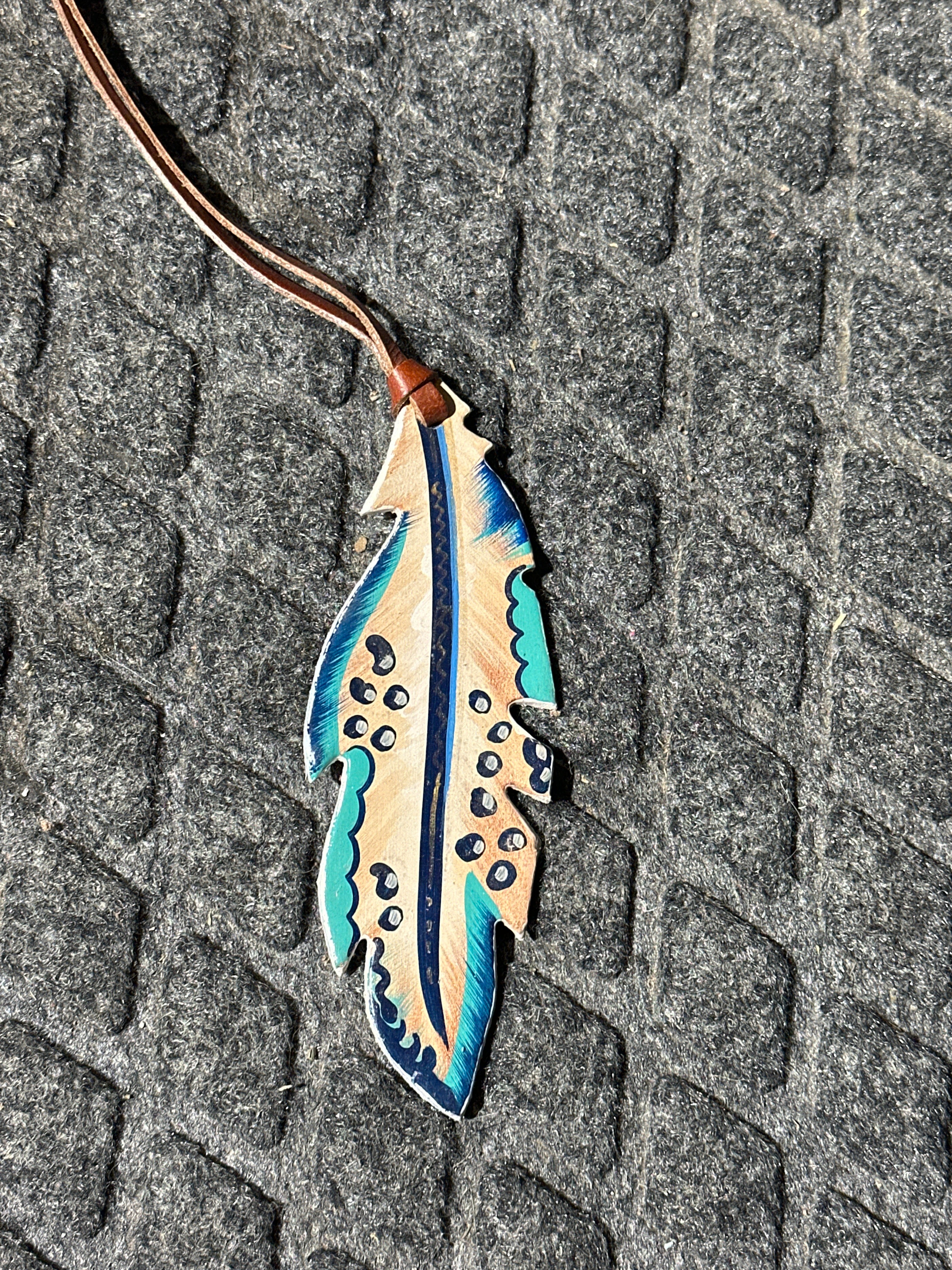 Leopard on earth tones painted feather tie on saddle charm